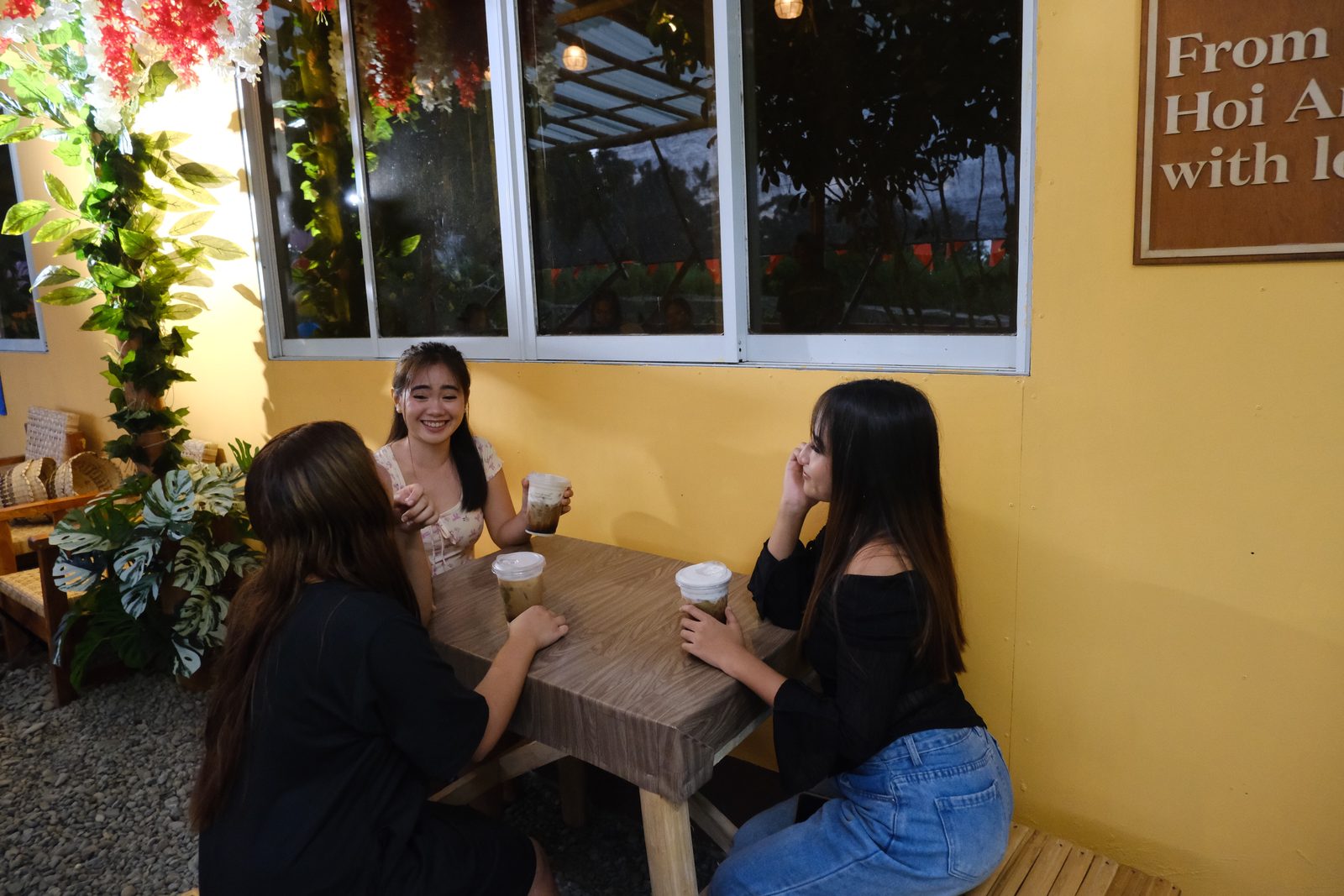 Friends chatting over drinks at a garden table in evening light